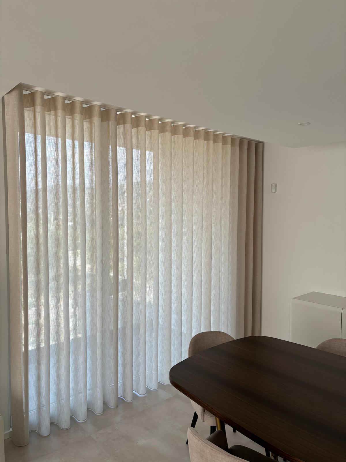Cortinado de onda suspenso em calha, numa sala de jantar