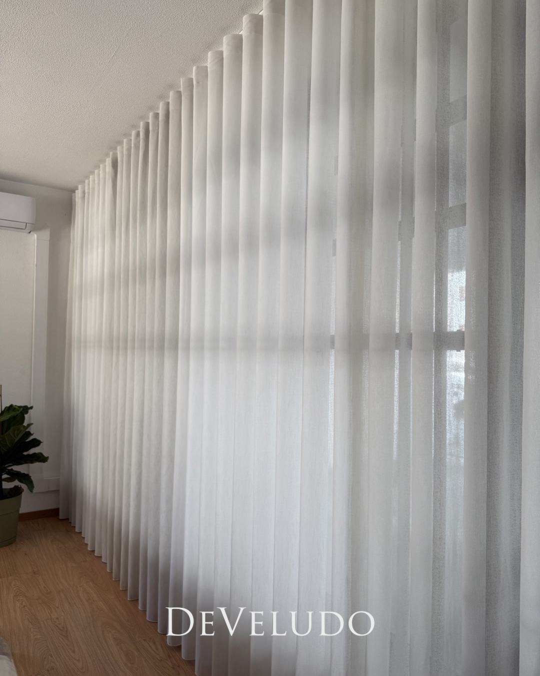 Cortinado de onda em tecido claro com a luz a atravessá-lo