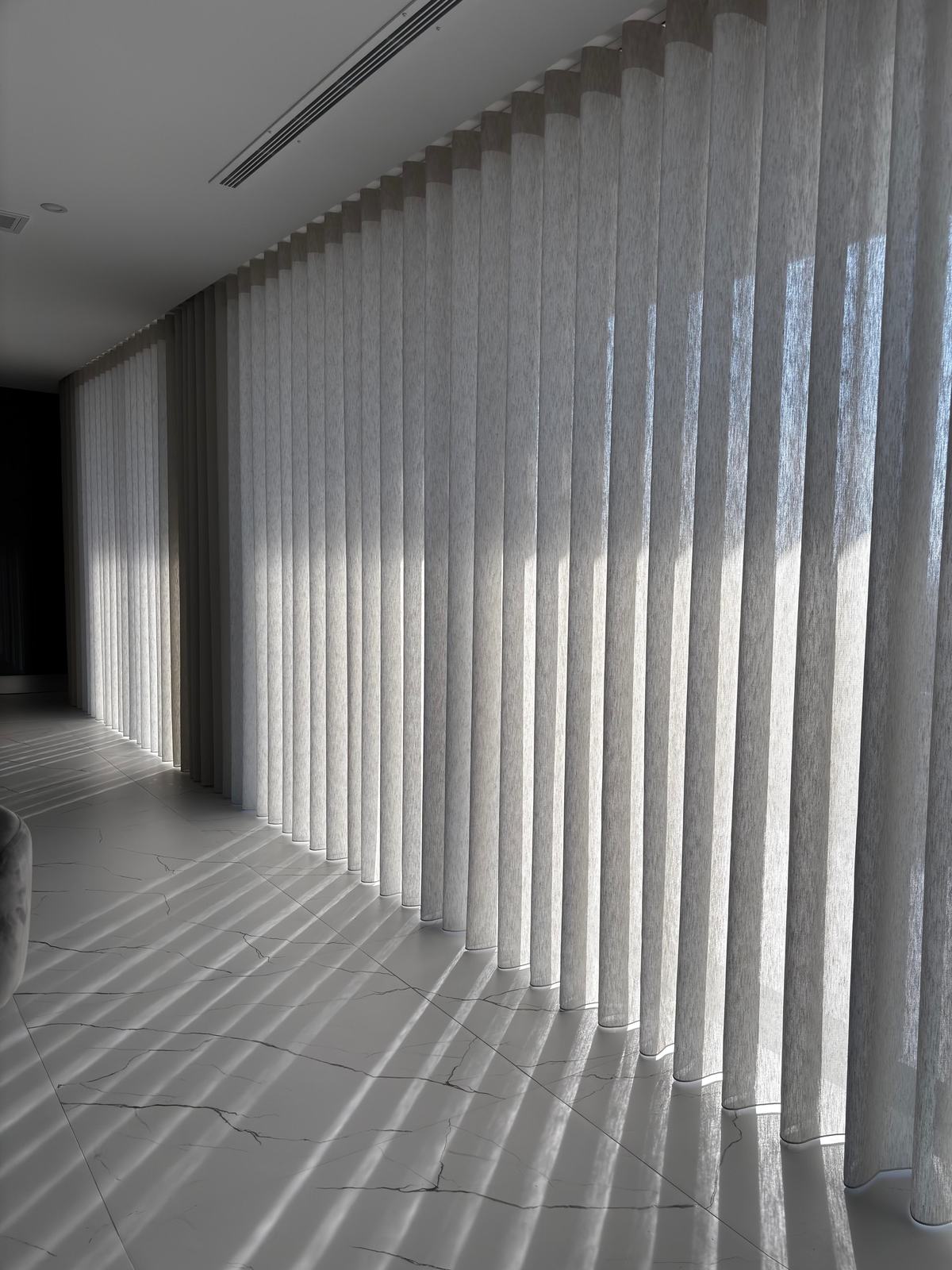 Pormenor da textura de um cortinado de onda com a luz do sol a atravessá-lo